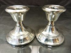 Pair of hallmarked silver candlestick London 1914 and 1912. Denting to top of one and wooden bases.