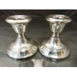 Pair of hallmarked silver candlestick London 1914 and 1912. Denting to top of one and wooden bases.