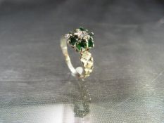 18ct White gold engagement ring with central diamond surround by six emeralds