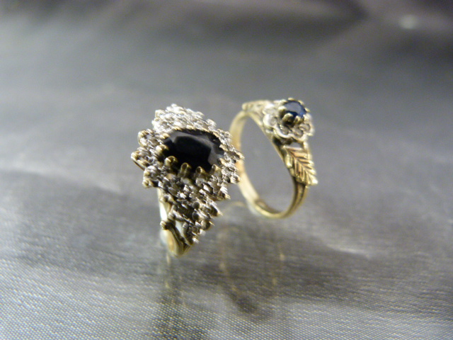 Two 9ct Gold rings. Both set with Central sapphire and surrounded by Diamonds. Size UK - (1) I