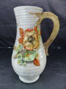 A Clarice Cliff Jug decorated with embossed Autumn fruits and flowers. No 914. Embossed mark to