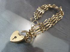 9ct gold ladies four bar bracelet with 9ct gold heart shaped lock (total weight approx. 9.1g)