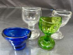 Victorian glass eye baths. Two clear glass, one green and the other Bristol Blue colour but marked