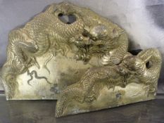 Two Japanese moulded metal crumb trays decorated with dragons to handles