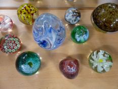 9 Glass Paperweights - To include 5 Caithness (Pebble, 3 x Mooncrystal and one other). All others