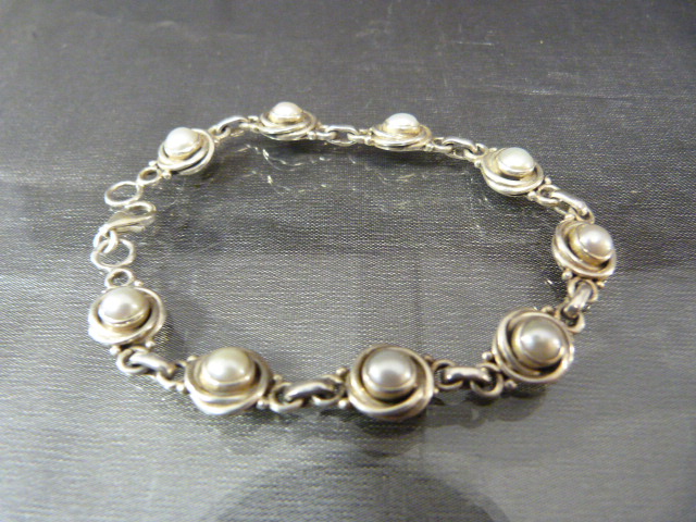 Hallmarked silver bracelet set with interspersed pearls in a circular design.