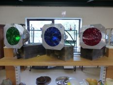 Three vintage theatre lights mounted on wooden stands