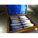 A set of twelve Victorian mother-of-pearl handled fruit knives and forks presented in inlayed box