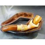 Carved Meerschaum in the form of a hand holding a bowl. Bowl made from amber as is the Mouthpiece in