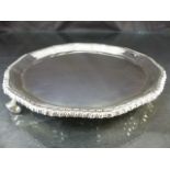 Hallmarked silver pie crust platter on tripod feet. Chased design to outer edge by Adie Brothers