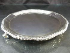 Hallmarked silver pie crust platter on tripod feet. Chased design to outer edge by Adie Brothers