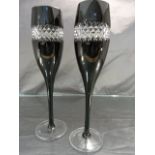 Pair of Champagne flutes by John Rocha for Waterford Crystal. Black Glass with a band of Diamond