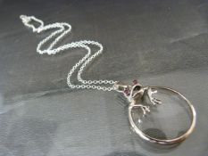 Silver magnifying glass with frog on chain