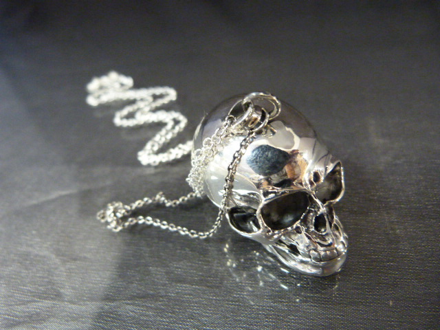 An unusual silver skull pendant necklace on a silver chain