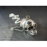 An unusual silver skull pendant necklace on a silver chain