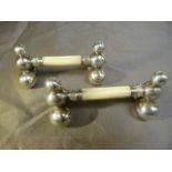 Pair of unmarked silver knife rests on graduation globe supports with the rest made from Mother of