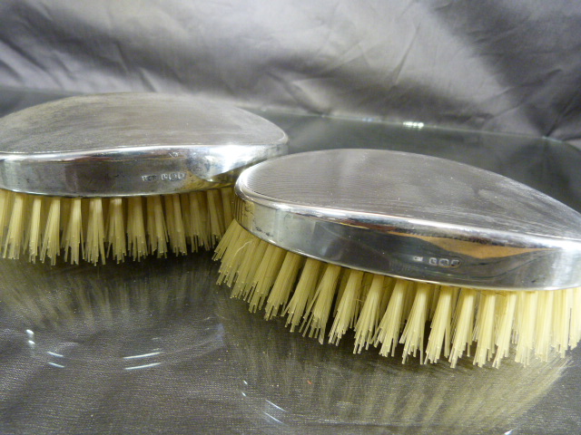 Pair of unused silver hallmarked clothes brushes with engine turned decoration, dated 1946