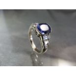 18ct white gold ring set with a pale ceylon Sapphire oval in shape and with stepped baguette