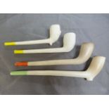 Four various antique clay pipes with coloured ends.