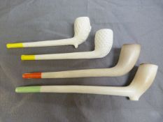 Four various antique clay pipes with coloured ends.