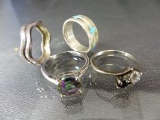Four silver rings including an 8.1mm diameter mystic topaz stone