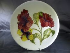 Moorcroft Circular plate with tube lining decoration of a floral Motif. Impressed 'Moorcroft' to