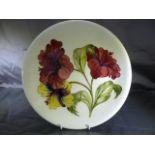 Moorcroft Circular plate with tube lining decoration of a floral Motif. Impressed 'Moorcroft' to