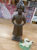 Two cast iron doorstops - one in the form of a woman in dress and the other of ducks