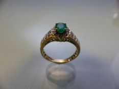 14CT yellow gold emerald and diamond ring, the large central stone surrounded by diamonds