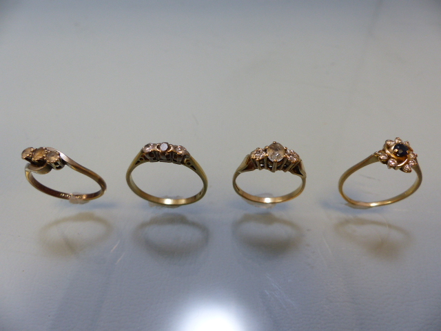 Three ladies 9ct dress rings and an 18ct (total weight 2.2g) three diamond stone ring (all A/F) (