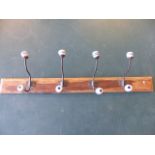 Vintage wall hanging coat rack with cast metal hooks leading to china blue and white balls.