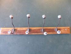 Vintage wall hanging coat rack with cast metal hooks leading to china blue and white balls.