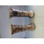 Pair of oriental stoneware vases with fluted rims. Damage to both tops. Decorated with Imari style