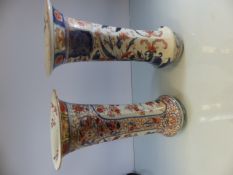 Pair of oriental stoneware vases with fluted rims. Damage to both tops. Decorated with Imari style