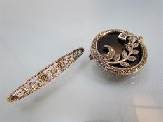 Two Marcasite set brooches. 1) Circular black Onyx with a silver 9.5 ribbon border and leaf design