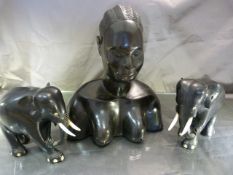 Ebonised carved bust of an African lady and two similar carved elephants