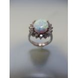 Silver ring with large central opal surrounded by CZs in a daisy style