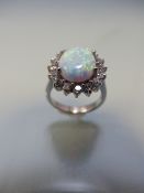 Silver ring with large central opal surrounded by CZs in a daisy style
