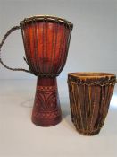 Two African drums, one Jemba with carved base, and one tribal cow hide covered Bongo.