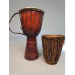 Two African drums, one Jemba with carved base, and one tribal cow hide covered Bongo.