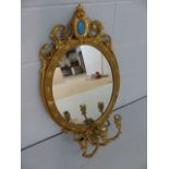 Antique Giltwood mirror in the Rococo manner with scrolling floral features and tri-arm candle