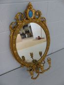 Antique Giltwood mirror in the Rococo manner with scrolling floral features and tri-arm candle