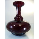 Early blood red glass bottle vase. The trumpet neck with a bulbous body on a two stepped base.
