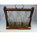 Oak cased Tantalus with brass handle. Three moulded glass decanters. Comes with key Lock A/F
