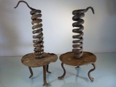 Two Early Mid 18th Century metal candle holders of simplistic form. The candle held by a spiralled