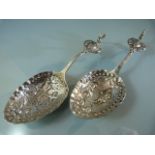 Pair of continental silver caddy spoons, with embossed figural decorations and cockerel terminal