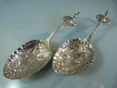 Pair of continental silver caddy spoons, with embossed figural decorations and cockerel terminal