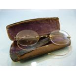Pair of frame less spectacles with gold coloured wire arms in metal case (A/F)