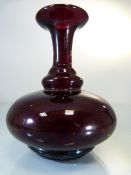 Early blood red glass bottle vase. The trumpet neck with a bulbous body on a two stepped base.