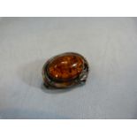 Art Nouveau silver brooch set with Amber cabochon.